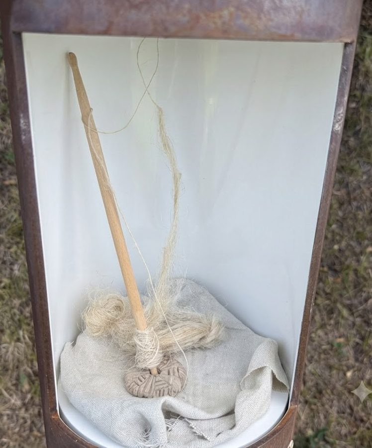 Vollst&auml;ndige Handspindel mit Leinengewebe in einer Vitrine